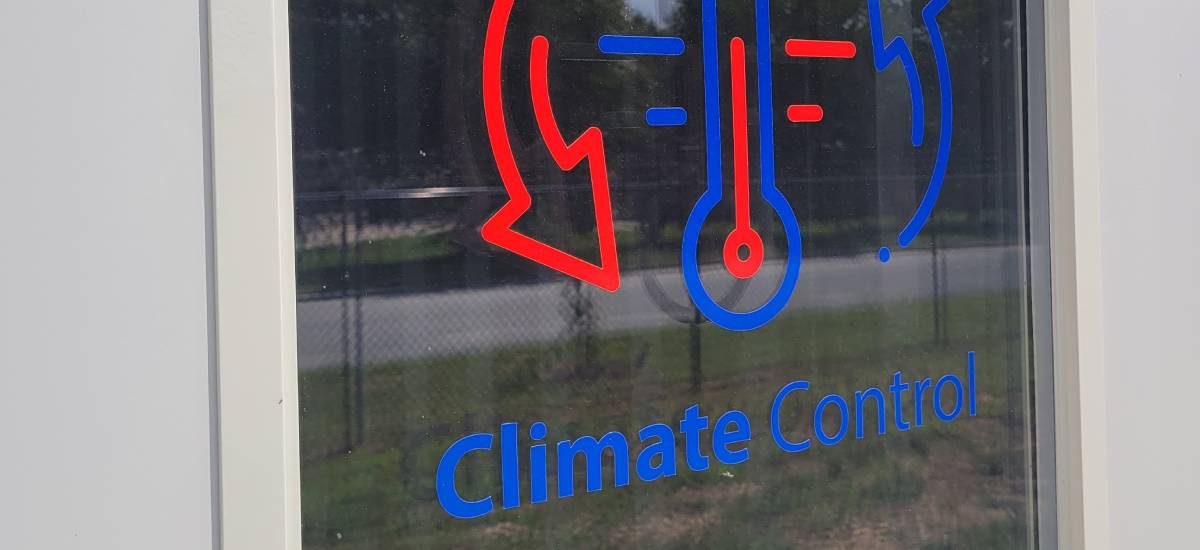 Climate control signage on storage unit window at Port City Movers facility.