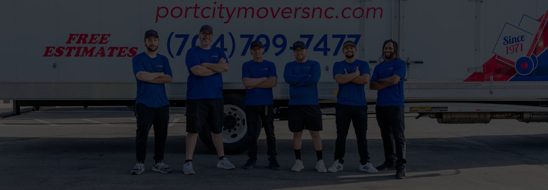 Six Port City Movers team members standing in front of a branded moving truck, posing confidently - dark overlay